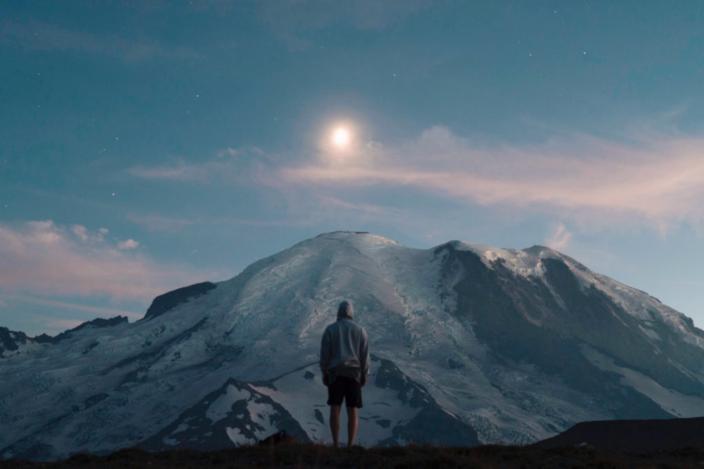 Person on mountain looking at moon